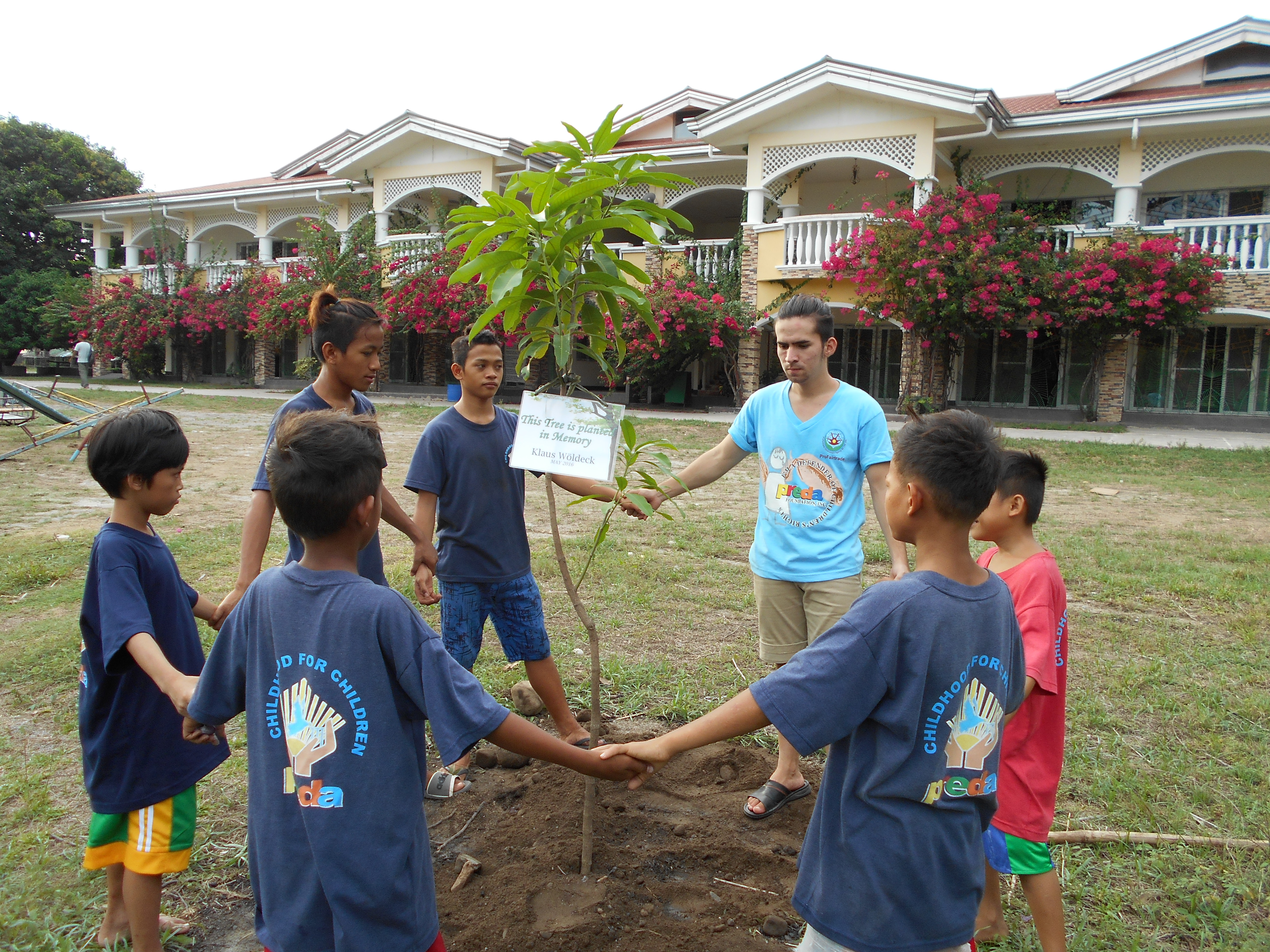 Children at the  Preda home for Boys  pray around a newly planted mango tree in memory of Klaus Woldeck. 